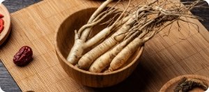Bowl of fresh ginseng roots with dried fruit, energizing component in Manboa for male vitality.