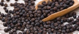 Spoon of black peppercorns, bioenhancer in Manboa male enhancement supplement for improved nutrient uptake.